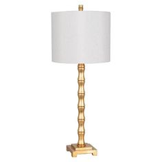 a gold table lamp with a white shade