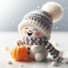 a snowman with a hat and scarf holding a small pumpkin in it's hands