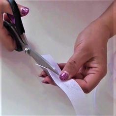 a woman holding scissors with pink glitter on it