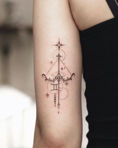 a woman's arm with a cross and stars tattoo on the back of her left arm