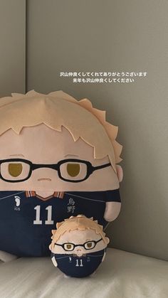 a stuffed animal with glasses on it's head next to a small doll in the shape of a football player