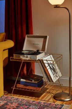 a lamp that is next to a table with some books on it and a record player