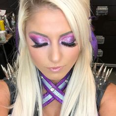 a woman with long blonde hair and purple makeup