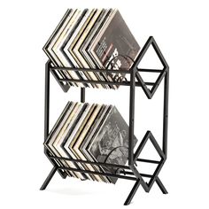 a black metal shelf with magazines on it's sides and an upside down magazine rack in the middle