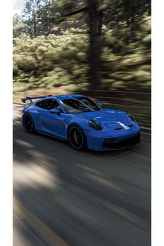 a blue sports car driving down the road