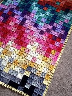 a crocheted blanket is laying on the floor