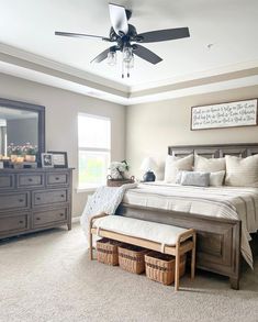 a bedroom with a bed, dressers and mirror in it's center area