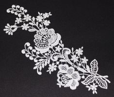 a white lace with flowers and leaves on a black background