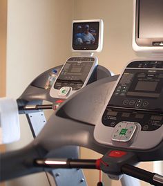 an exercise room with treads, monitors and other equipment in it's display area