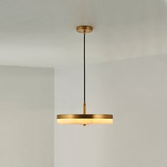 a light fixture hanging from the ceiling in a room with white walls and flooring