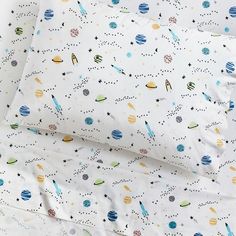 a bed with space themed sheets and pillowcases on top of eachother