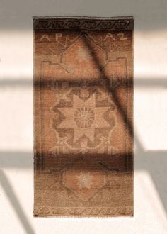 the shadow of a rug is cast on the wall by a light coming through it