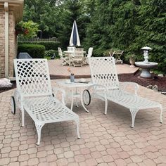 three white patio furniture sitting on top of a brick patio