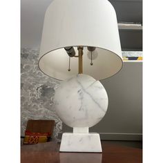 a marble lamp with a white shade on it