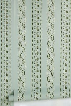 the wall paper is green and white with intricate designs on it's sidewall