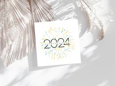 a greeting card with the year 2021 on it next to some palm leaves and flowers