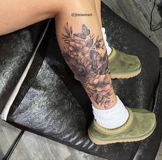 a woman's legs with flowers and butterflies tattooed on her left leg, sitting on a black chair