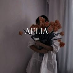 a woman holding a bouquet of flowers in her hands with the word aelia on it