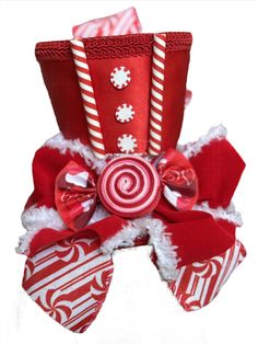 Peppermint Nutcracker Top Hat Add some fun to your Nutcracker shoots with the Peppermint Nutcracker Top Hat by The Head Mistress. A red satin top hat embellished with sweet peppermint accents, peppermint candy bow and candy striped ribbon makes this top hat a must-have sweet addition to your candy nutcracker photo shoots! This top hat is fixed to a headband and fits all ages. Premium Quality: Crafted from the finest materials for durability. Exclusive Design: Stand out with its unique and eye-ca Christmas Hats, Red Satin Top, Fabric Photography, Mean Green, Striped Ribbon, Diy Hat, Peppermint Candy, How To Make Ribbon, Candy Stripes