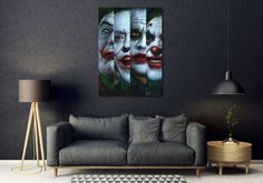 a living room with a couch and two paintings on the wall, one of which has three clowns painted on it