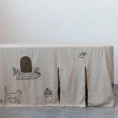 an image of a table cloth with cats and potted plants on the front cover