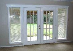 an empty room with french doors and windows