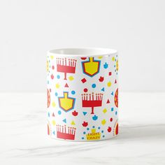 a white coffee mug with colorful designs on it