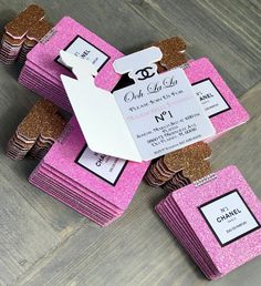 pink and gold glitter wedding favors with white tags on the top are stacked up against each other