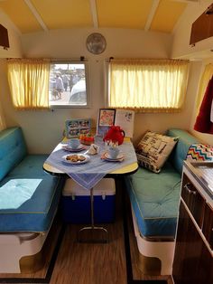 the inside of a camper with blue cushions