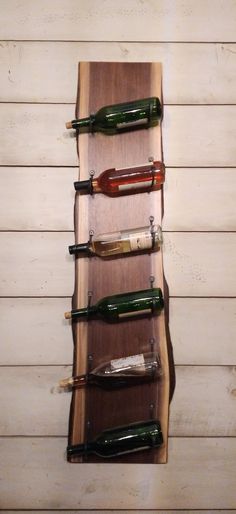 there is a wine rack made out of wooden planks and bottles on the wall