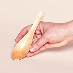 a person holding a wooden spoon in their hand