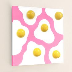 three eggs on a pink and white background with yellow circles in the middle, as well as an egg yolk