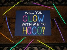 a sign that says will you glow with me to hoco? on the floor