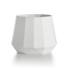 a white vase sitting on top of a table