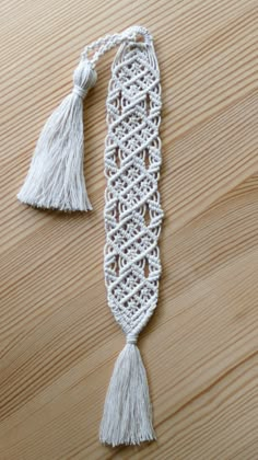 a white tasseled bookmark sitting on top of a wooden table