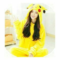 a woman in a pikachu costume sitting on the floor with her hands up