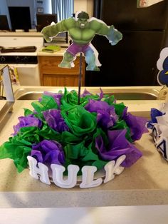 the hulk cake is decorated with green, purple and white icing on top of it