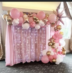 the balloon arch is decorated with pink, gold and white balloons