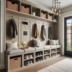 an entryway with several coats and shoes hanging on the wall, along with baskets