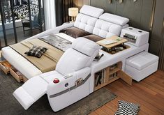 a white leather bed sitting on top of a hard wood floor next to a zebra rug