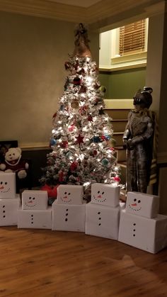 a white christmas tree with snowmen around it