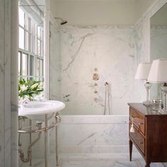 a bath room with a sink a mirror and a bath tub sitting next to a window