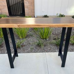 a wooden table sitting on top of a sidewalk