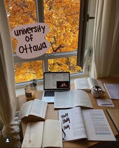 an open book sitting on top of a desk next to a laptop computer and books