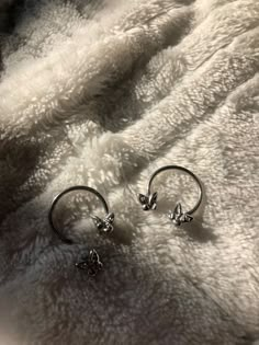 two silver rings laying on top of a white blanket