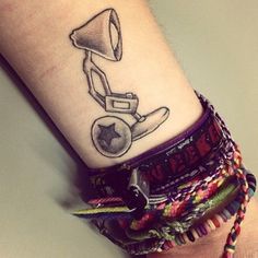 a tattoo on the wrist of a person with a small lamp in it's hand