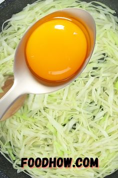 a frying pan filled with shredded cabbage and an egg