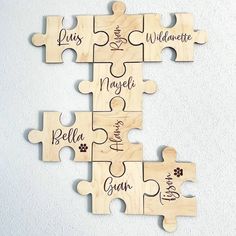 personalized wooden puzzle pieces with names and pictures on them, set against a white wall