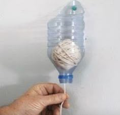 a hand holding a ball of yarn on top of a string attached to a water bottle