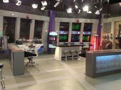 a television studio with chairs and desks in front of them, lights on the ceiling